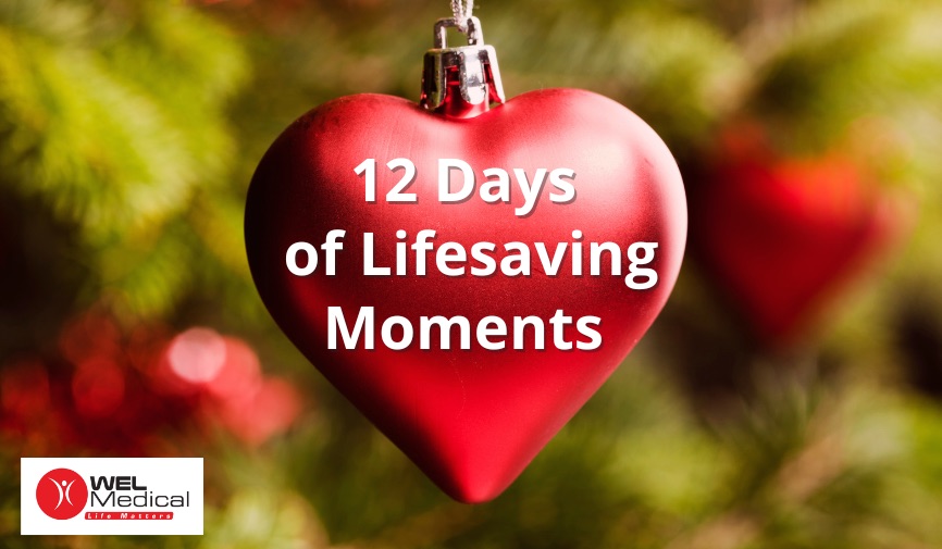 Red christmas bauble shaped like a hearrt, blurred christmas tree in background, white text reading 12 Days of Lifesaving Moments, and the WEL medical logo in the left bottom corner.