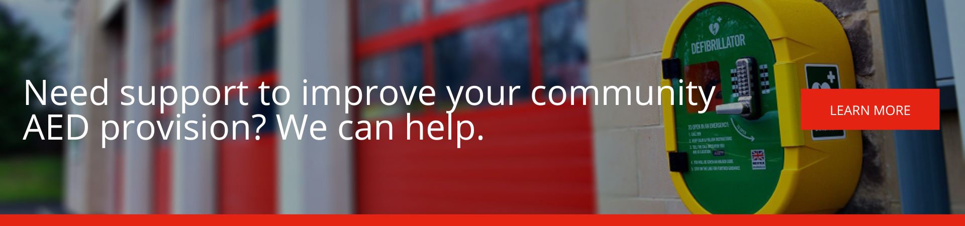 Need support to improve your community AED provision? We can help: A banner advertisement featuring a close-up of a yellow and green wall-mounted defibrillator cabinet outside a red-doored building, with a red "Learn More" button.
